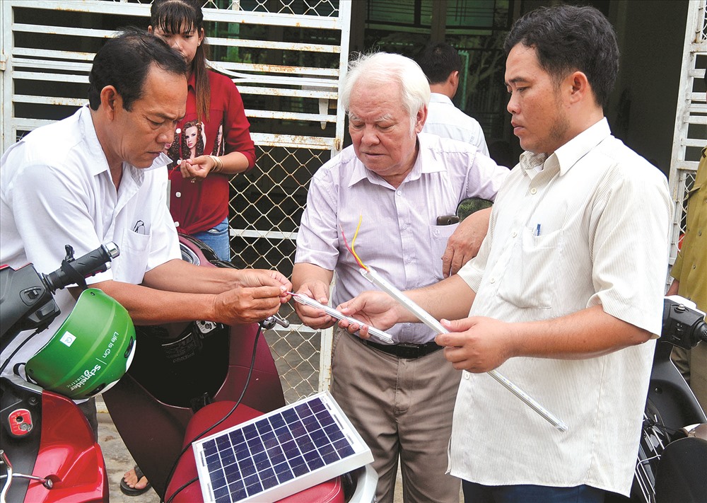 TS Nguyễn Văn Khải (giữa) hướng dẫn kỹ thuật Pin NLMT cho người dân Tà Lọt (An Hảo). Ảnh: Lâm Điền