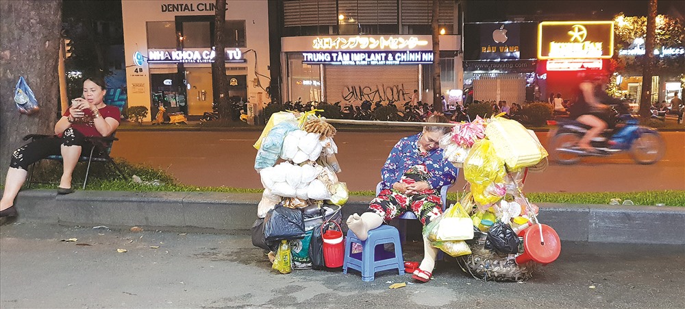 Người bán hàng rong tranh thủ nghỉ ngơi trên phố Trần Hưng Đạo. Ảnh: Trần Nam Luân