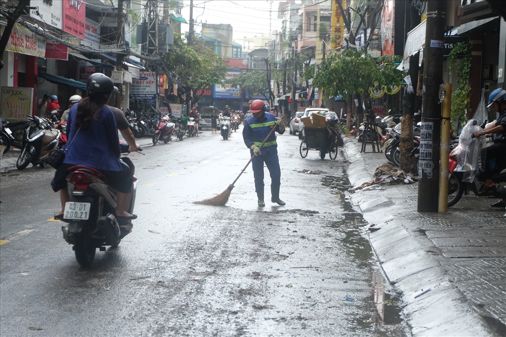 Các nhân viên vệ sinh môi trường đi dọn dẹp đường phố.