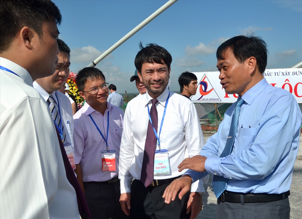 Ông Nguyễn Văn Dương (phải ảnh) trao đổi, chia sẻ với các chuyên gia, cán bộ có trách nhiệm trong công trình cầu Cao Lãnh trong ngày hợp long. Ảnh: Lục Tùng