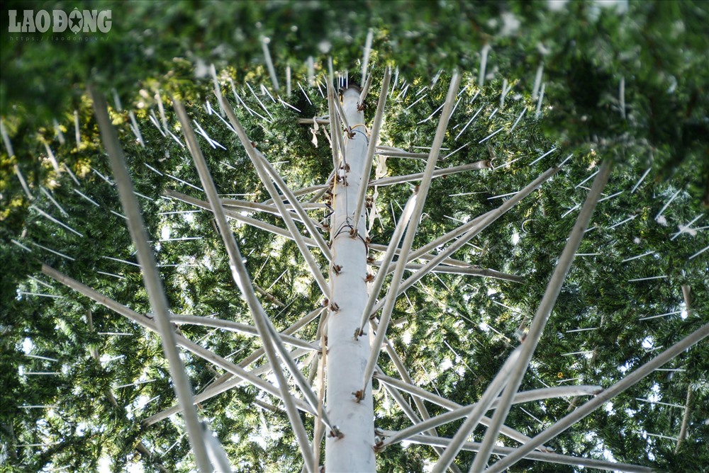 Những thanh sắt bắt ốc vít được nối vào thân cây thông bằng sắt để làm giá đỡ cho tán cây.