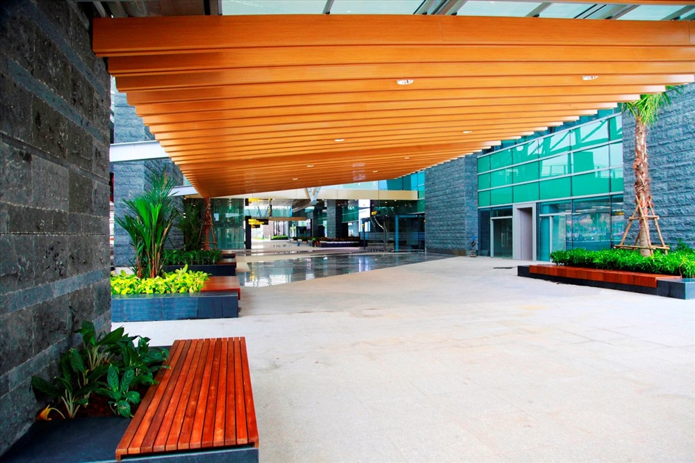 Phần mái che khu vực sảnh bên ngoài nhà ga sân bay được sử dụng kính Low-E có tác dụng giảm bức xạ nhiệt, chống nóng hiệu quả, đồng thời kết hợp hài hòa với hệ thống lam gỗ, đem đến nét sang chảnh. Ảnh: T.N.D 
