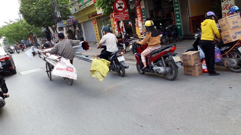 Xe xích lô chở tôn và ống thép kim loại cồng kềnh trên tuyến phố Trần Nguyên Hãn luôn đông đúc người đi lại. 