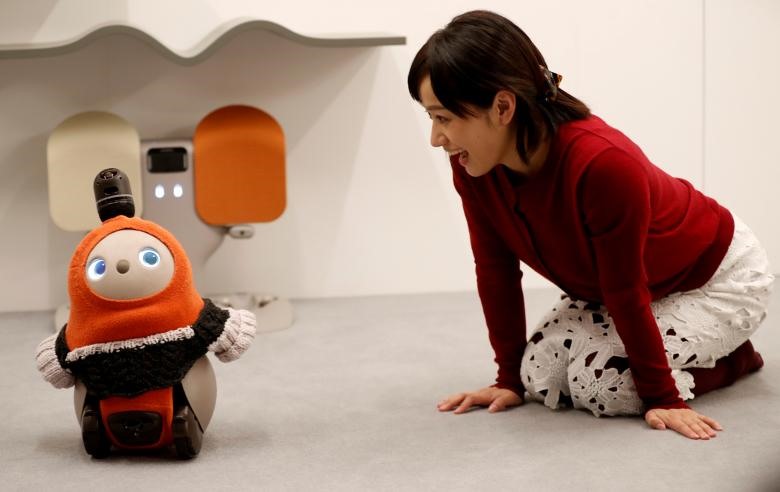 Một người phụ nữ nói chuyện với LOVOT - robot của GROOVE X tại một sự kiện ra mắt ở Tokyo, Nhật Bản. 