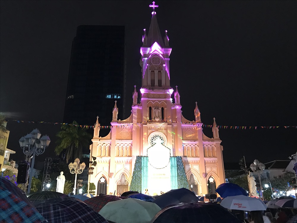 Giáo dân dùng dù che mưa trong lúc cử hành nghi lễ Canh thức tại nhà thờ Chánh Tòa Đà Nẵng.