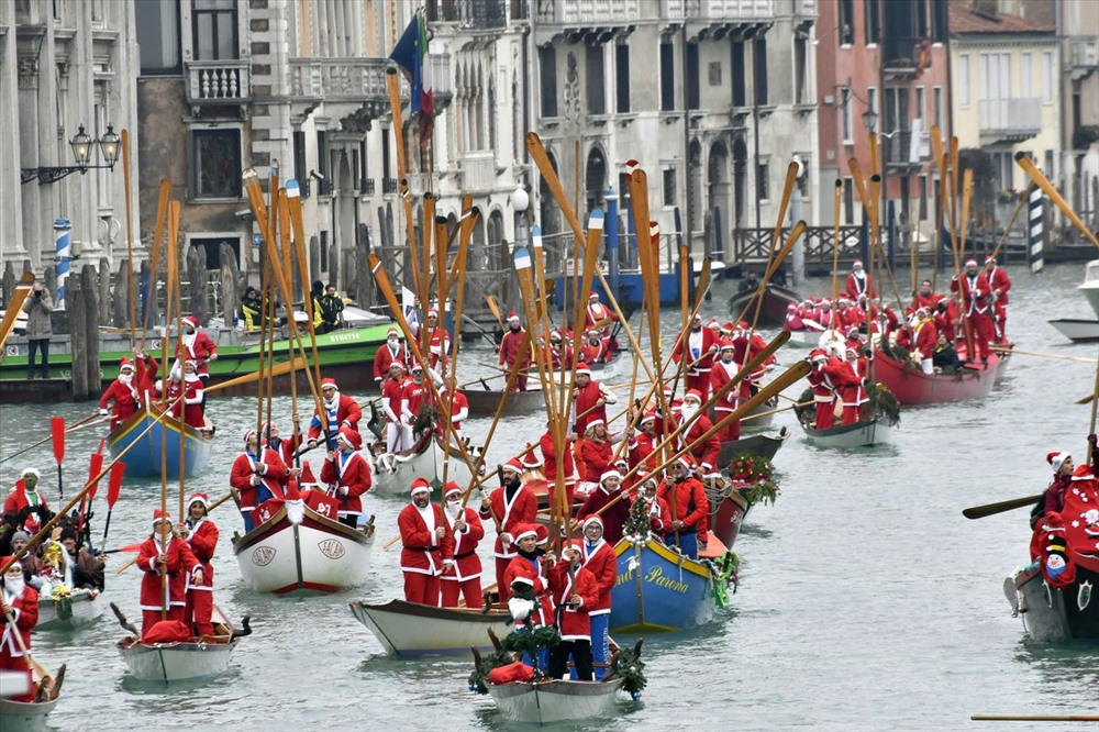 Người Ý mặc trang phục ông già Noel đi thuyền dọc theo kênh đào Grand Canal của Venice trên những chiếc thuyền truyền thống.