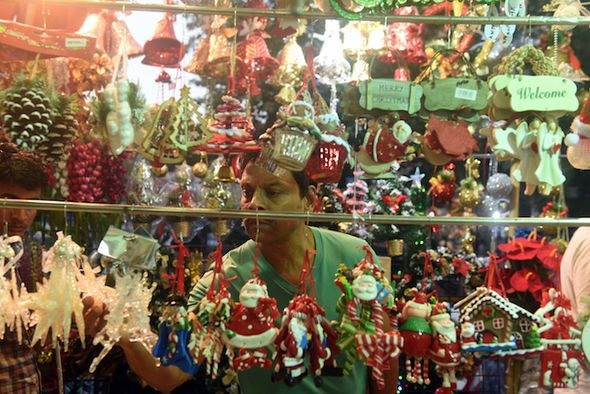 Một người đàn ông kiểm tra trang trí Giáng sinh trong một cửa hàng tại IC colony, Borivali, Mumbai