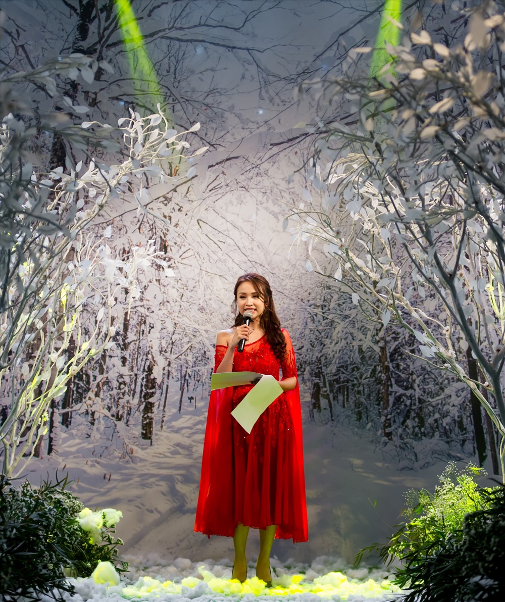 MC Thanh Vân Hugo diện váy đỏ nổi bật trong bối cảnh khu rừng tuyết trắng của Vietnam Kids Fashion Week.