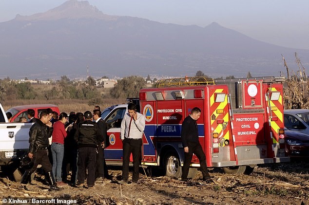 Các thành viên an ninh làm việc tại khu vực máy bay trực thăng gặp nạn ở Coronango, Puebla, Mexico.