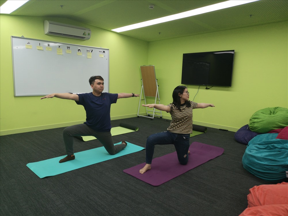Tập yoga tại văn phòng công ty vào giờ nghỉ, một ví dụ về các chương trình chăm lo cho người lao động - Ảnh: Navigos Group