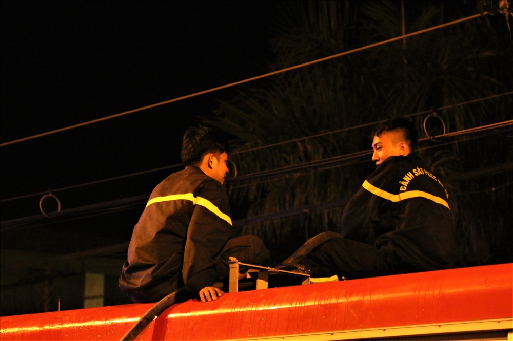 Hai chiến sĩ cảnh sát PCCC đang ngồi trò chuyện trên một bồn xe chứa nước sau khi đám cháy được dập tắt. Ảnh: Bảo Trung