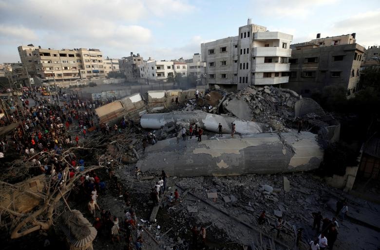 Người Palestine tập trung quanh một tòa nhà sau khi nó bị máy bay Israel ném bom, tại thành phố Gaza, ngày 9.8.2018.