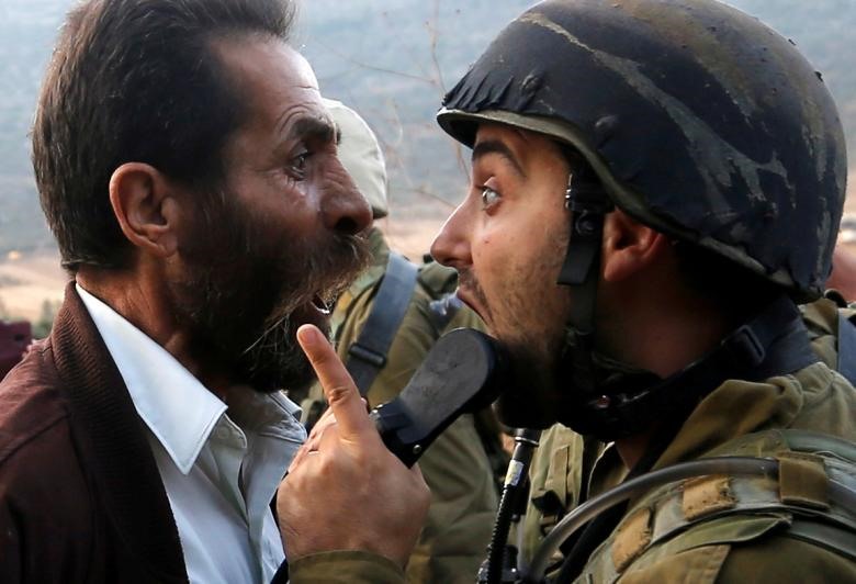 Một người đàn ông Palestine tranh cãi với một người lính Israel khi những người Palestine phản đối Israel đóng cửa một trường học Palestine gần Nablus ở Bờ Tây bị chiếm đóng, ngày 15.10.2018.