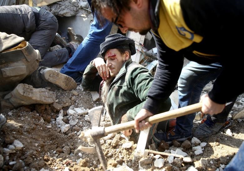 Một người đàn ông bị mắc kẹt dưới đống đổ nát sau cuộc không kích ở khu vực Saqba, ở vùng ngoại ô phía đông Damascus của Ghouta, Syria, ngày 9.1.2018.