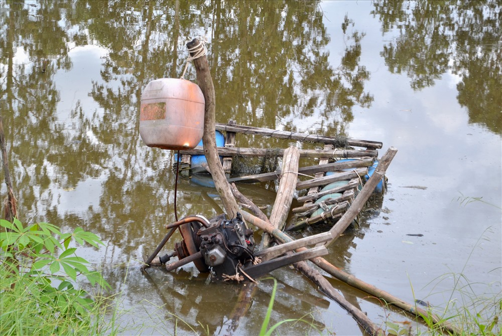 Nông dân đưa máy xuống ruộng bơm rút nhưng vẫn không thể cải thiện nạn nước ngập ruộng. Ảnh: Lục Tùng