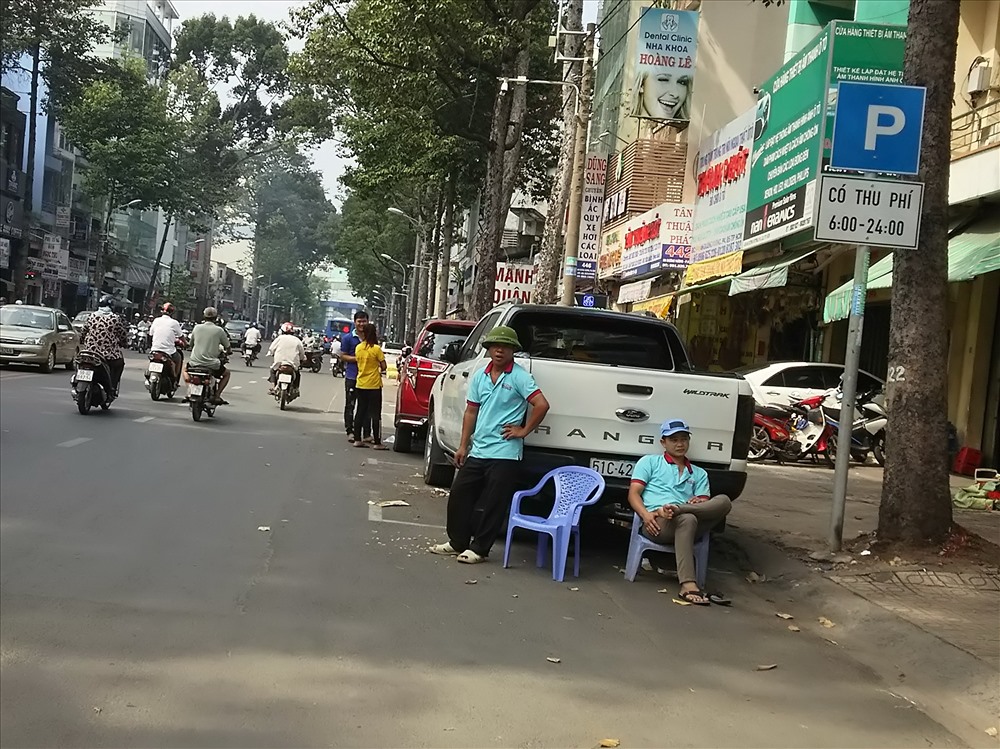 Nhân viên một cửa hàng sửa chữa và buôn bán phụ kiện ô tô trên đường An Dương Vương (Q.5) tràn ra chiếm khu vực đậu xe có thu phí để bắt khách.