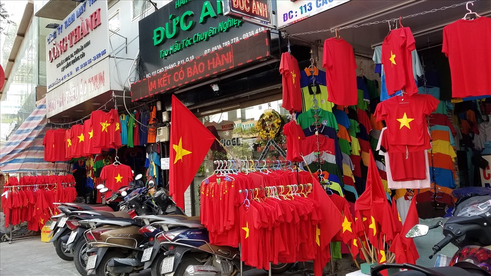 Nhiều cửa hàng tại khu vực đường Cao Thắng, quận 3 các mặt hàng thời trang như cờ, áo, băng rôn... được bài trí bắt mắt.