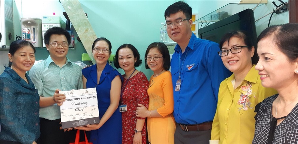 Đại diện CĐ Trường THPT Phú Nhuận trao tặng quà cho vợ chồng thầy Ngọc Thanh và cô Ngọc Anh. Ảnh: CĐ Giáo dục TP. Hồ Chí Minh