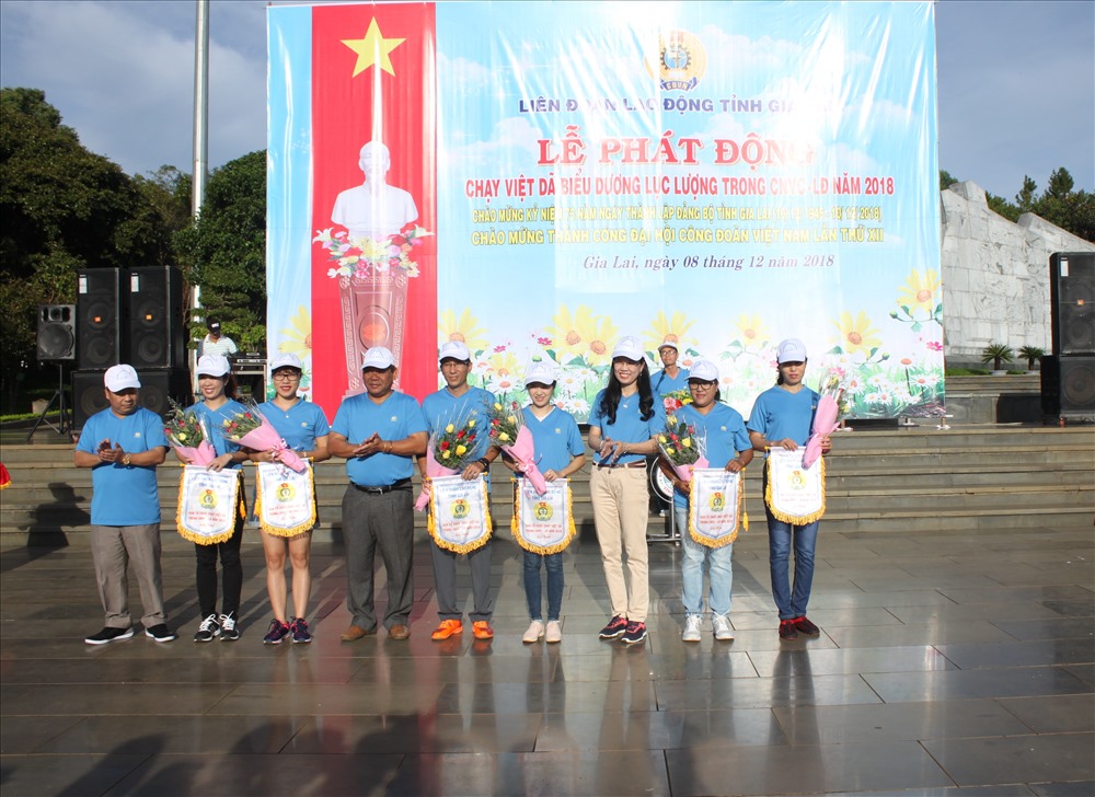 Ban Tổ chức trao tặng cờ lưu niệm cho đại diện các đơn vị công đoàn ngành tham dự chạy Việt dã, trước lúc xuất phát. Ảnh Đình Văn