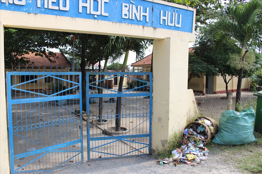 Ngay cổng trường là những thùng rác đổ tràn ra cổng.