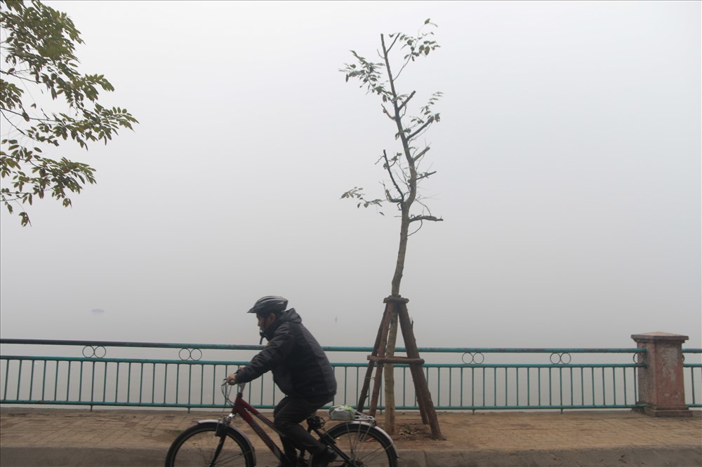 Hồ Tây bị sương dày bao phủ. Từ đường Nguyễn Đình thi nhìn qua hồ không thể thấy mặt nước như ngày thường.
