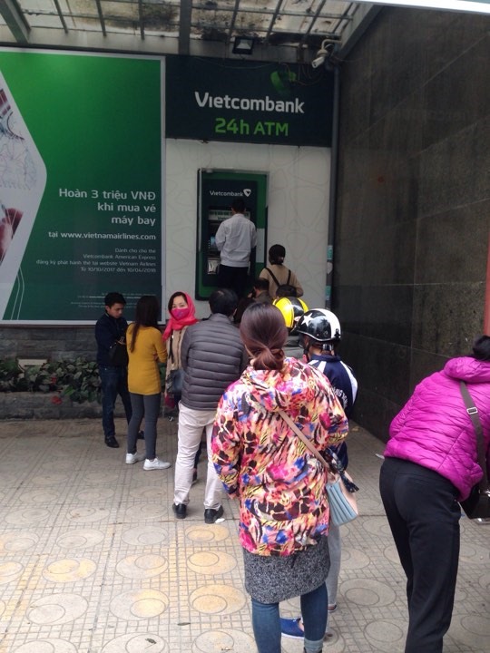 Ngân hàng Vietcombank ở Duy Tân sáng ngày 25 tháng Chạp, hàng dài người nối đuôi nhau chờ đến lượt mình rút tiền. (Ảnh: HH)
