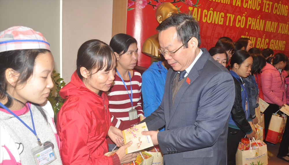Đồng chí Phùng Quốc Hiển - Ủy viên T.Ư Đảng, Phó Chủ tịch Quốc hội - tặng quà cho công nhân khó khăn của Cty cổ phần May xuất khẩu Hà Bắc (Bắc Giang) ngày 6.2. Ảnh: QUẾ CHI