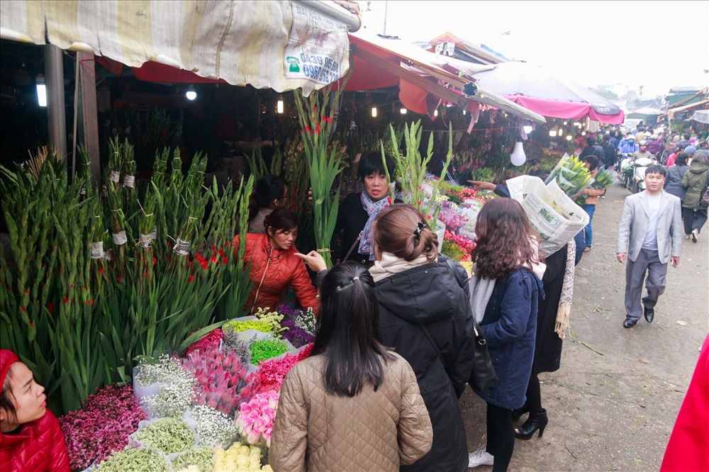 Tại chợ hoa đầu mối Quảng An, Hà Nội, những gian hàng bán hoa hồng chật kín người mua. Ngày mai là 29 tết Nguyên đán đồng thời cũng là ngày Lễ tình nhân nên hoa hồng trở thành mặt hàng được “săn tìm“.