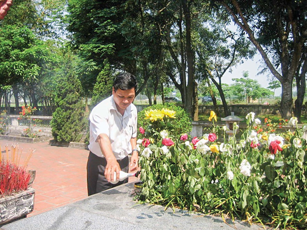 Hàng ngày, du khách đến cắm hoa và rót rượu trên mộ Nguyễn Du. Ảnh: Trần Đăng.