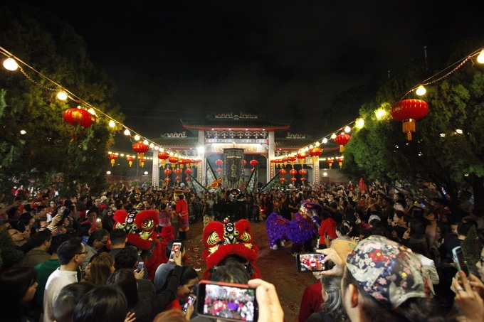 Gần 12 giờ đêm, thời khắc giao thừa, chùa Bà Thiên Hậu đã tấp nập người đến làm lễ. Đây là một địa điểm quen thuộc của nhiều người gốc Việt mỗi dịp Tết đến. Trong ảnh, màn múa lân tại chùa thu hút hàng trăm người đến xem.