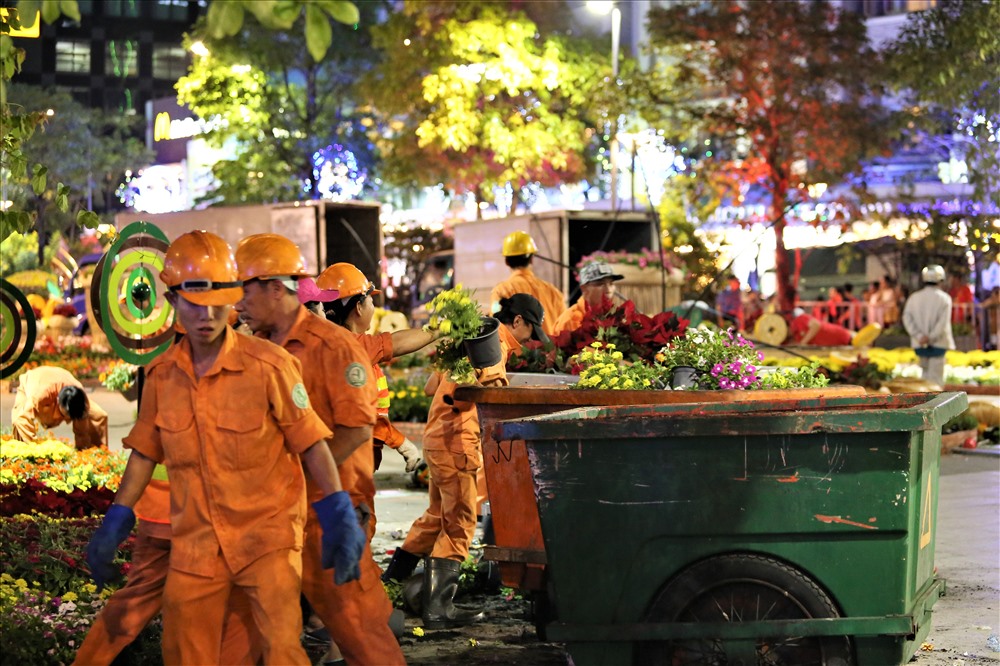 Hàng nghìn chậu hoa các loại sau nhiều ngày trang trí trên đường hoa được công nhân cho vào các xe đẩy để đưa ra xe ép rác chuyên dụng. Ảnh: Trường Sơn