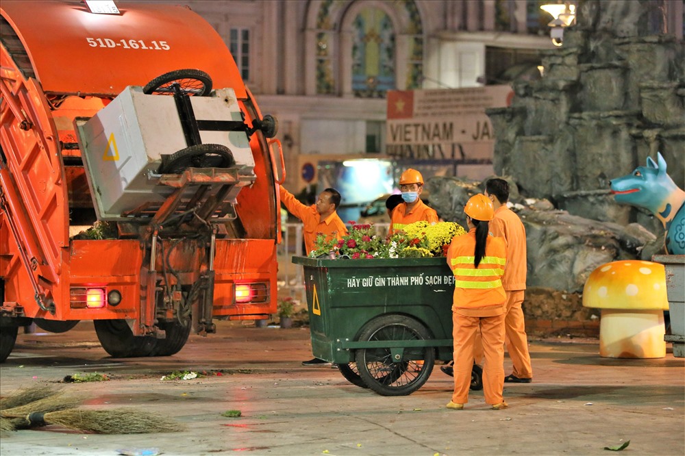 Đúng 22h, hàng chục xe ép rác cùng hàng trăm công nhân được huy động để thu dọn đường hoa Nguyễn Huệ. Ảnh: Trường Sơn