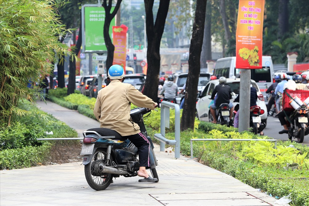 Một người lái xe máy đang “phi” lên vỉa hè đường Nguyễn Thị Minh Khai thì đụng ngay thanh chắn mới được lắp đặt. Ảnh: Trường Sơn