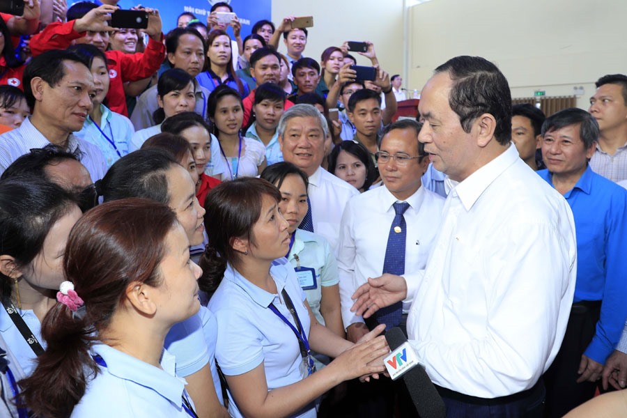 Chủ tịch Nước Trần Đại Quang ân cần thăm hỏi công nhân lao động Công ty Esquel Garment (Bình Dương) ngày 30.1. Ảnh: TTXVN