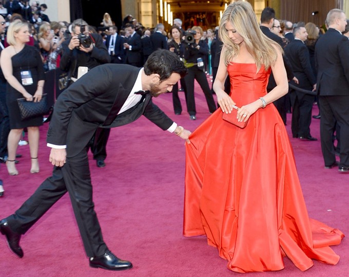 Justin Theroux chỉnh váy cho hôn thê trên thảm đỏ giải Oscar vào tháng 2.2013.