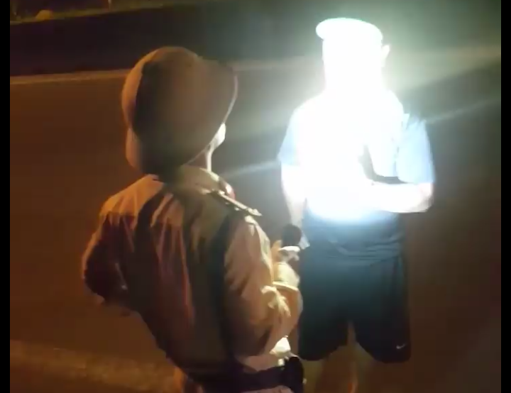 Cán bộ CSGT có hành vi rọi đèn pin vào thẳng mặt người lái xe. Ảnh: Cắt từ clip