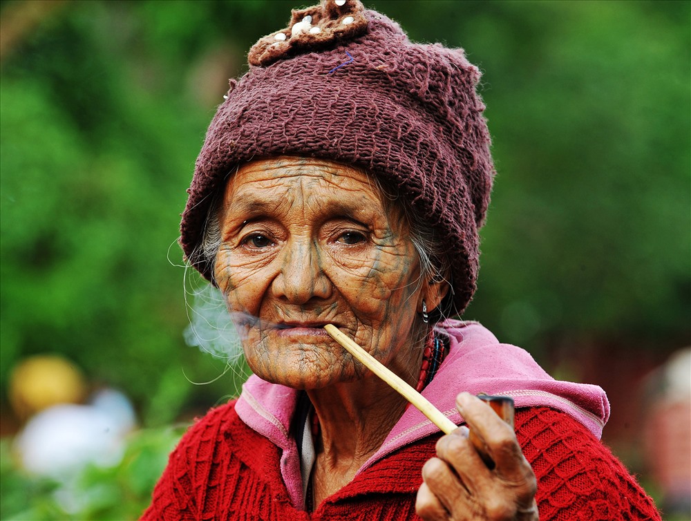 Những người phụ nữ xăm mặt sống ở Chin rất hay hút thuốc, nhất là vào những ngày đông lạnh giá.