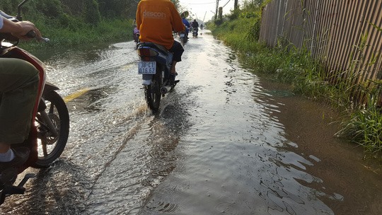 Sáng 4-2, triều cường gây ngập ở khu vực quận 9, TPHCM khiến giao thông đi lại khó khăn.