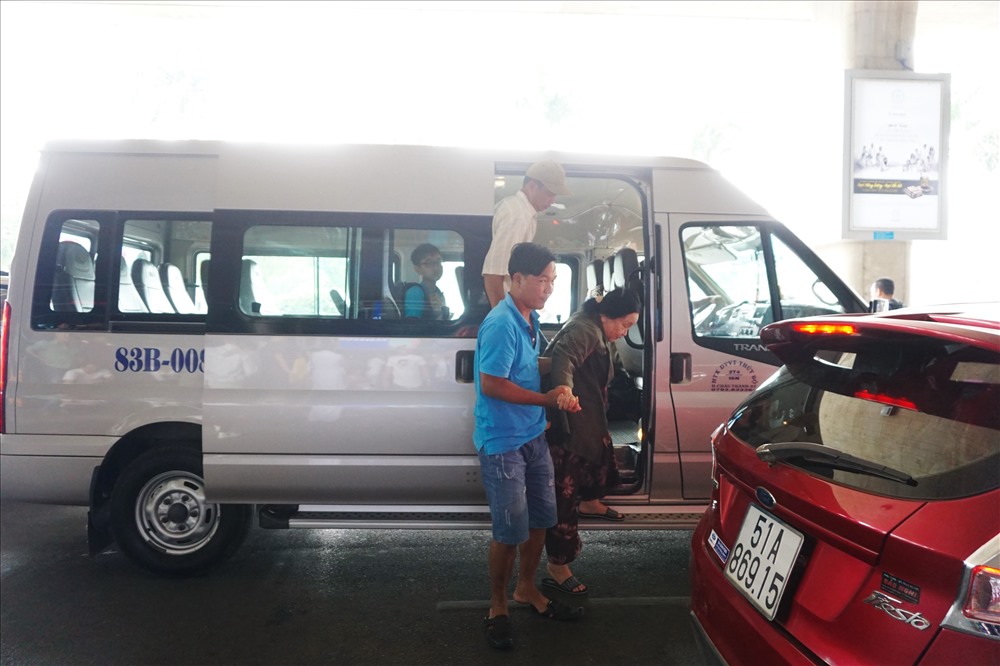 Một gia đình thuê xe 16 chỗ đến sân bay Tân Sơn Nhất đón người thân.  Ảnh: M.Q