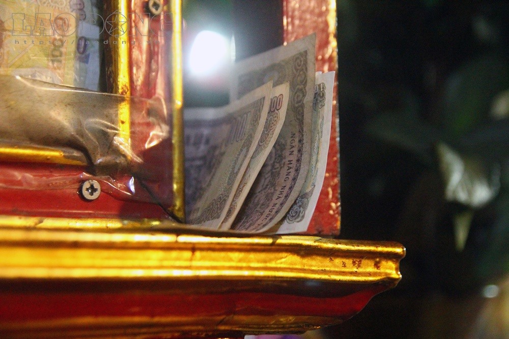 Nhiều người đặt tiền lẻ bên ngoài tượng Ban Hoàng Đôi.