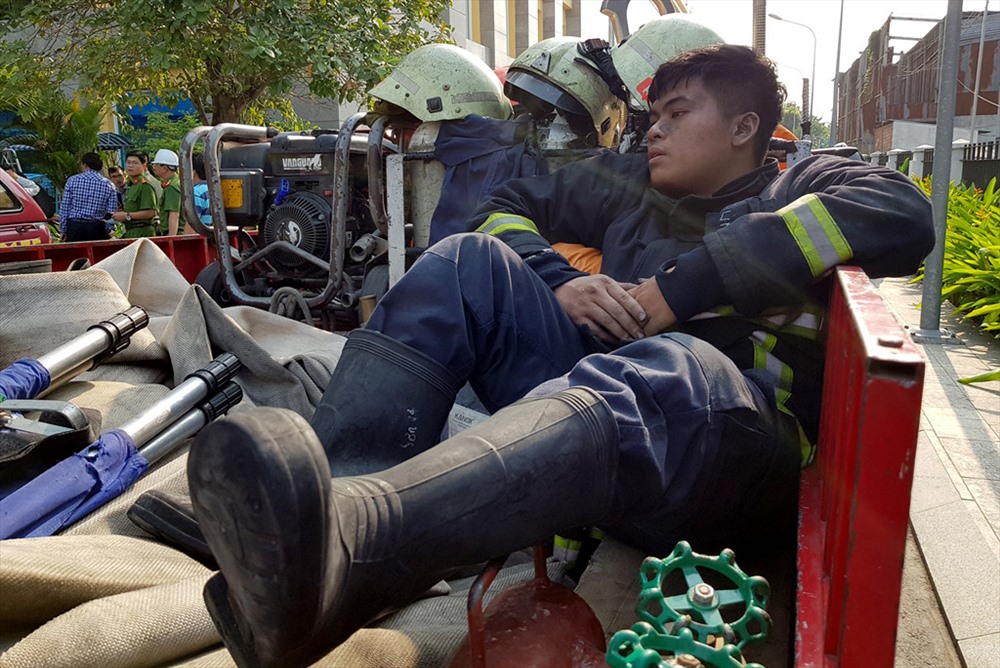 Sau khi dập tắt đám cháy và cứu hàng trăm người dân thoát nạn, các chiến sĩ Cảnh sát PCCC gần như mệt lả, kiệt sức - ảnh Lê Trai - Zing.vn