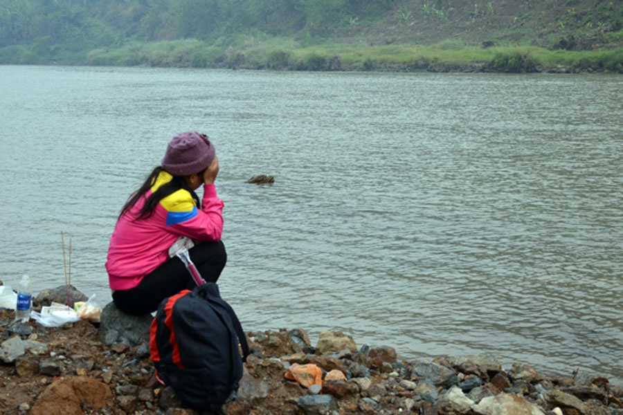 Người thân của một nạn nhân ngồi khóc bên bờ sông Hồng. Ảnh: Baolaocai.vn