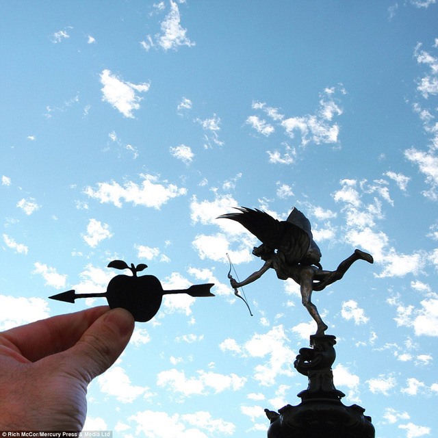 Hình cắt mũi tên xuyên qua quả táo được đặt cạnh bức tượng giữa ngã tư Piccadilly Circus.
