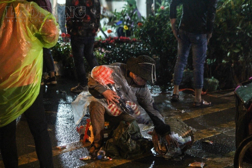 Tại chợ Viềng (Nam Định) đêm mùng 7 tháng Giêng (22.2), nhiều người ôm theo trẻ em nằm dưới đường rồi lăn theo dòng du khách xin tiền tạo nên những hình ảnh phản cảm. Ảnh: Cường Ngô