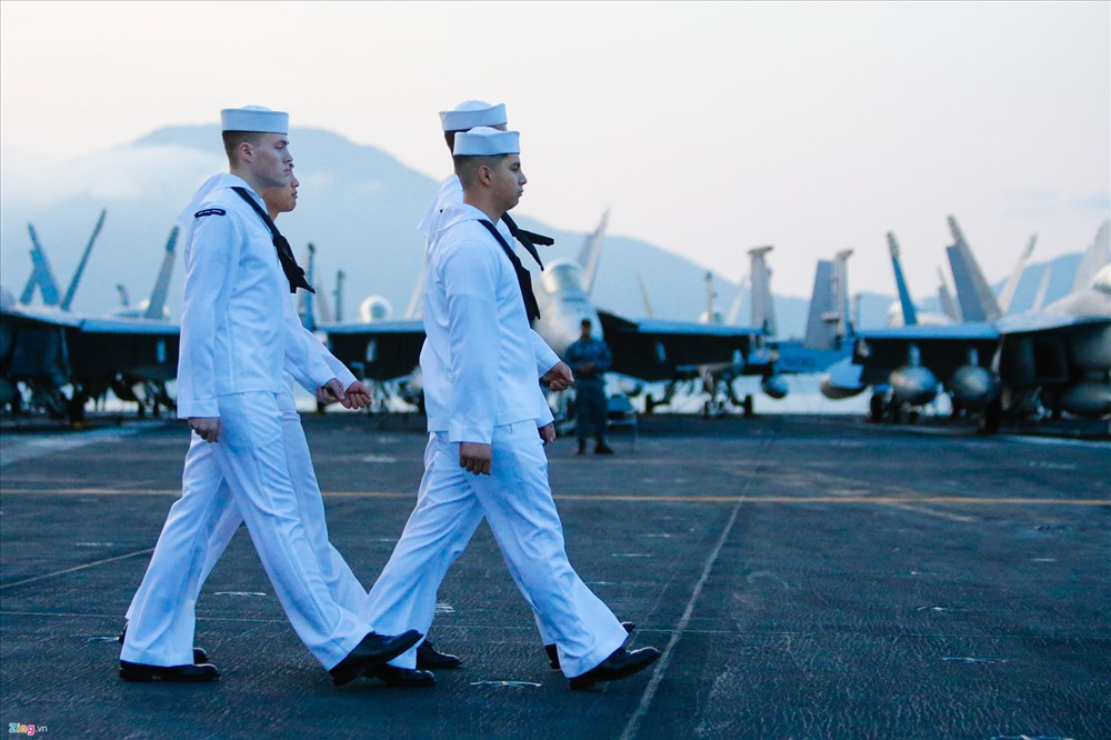Bốn thủy thủ trên tàu sân bay USS Carl Vinson chuẩn bị thực hiện nghi thức chào cờ vào cuối giờ chiều hàng ngày hôm 5/3. Hàng không mẫu hạm của Hải quân Mỹ hiện dừng chân tại vịnh Đà Nẵng trong chuyến thăm kéo dài năm ngày.