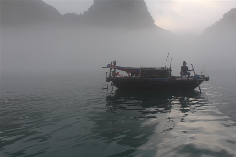 Thuyền đánh cá ẩn hiện trong sương giăng giữa vịnh Hạ Long