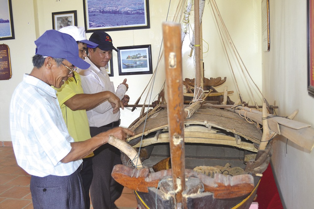 Du khách tìm hiểu mô hình ghe câu được phục dựng và trưng bày tại Nhà trưng bày đội Hoàng Sa Bắc Hải.