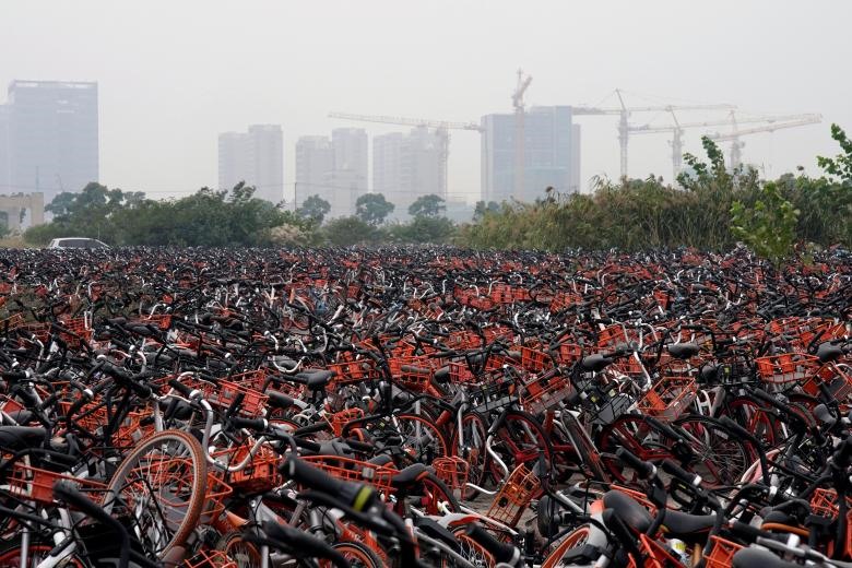 Các công ty cung cấp dịch vụ chia sẻ xe đạp ở Trung Quốc dựa trên ứng dụng điện thoại. Khách hàng có thể tìm xe và trả xe tại mọi địa điểm, tiền thuê được trả qua ứng dụng. Để đảm bảo luôn có xe ở mọi địa điểm, các công ty đã cung cấp xe đạp khắp các thành phố. Tuy nhiên, vì lượng cung vượt quá lượng cầu dẫn đến cảnh nhiều khu đất trống trở thành “nghĩa địa” của hàng nghìn chiếc xe đạp. (Ảnh: REUTERS)