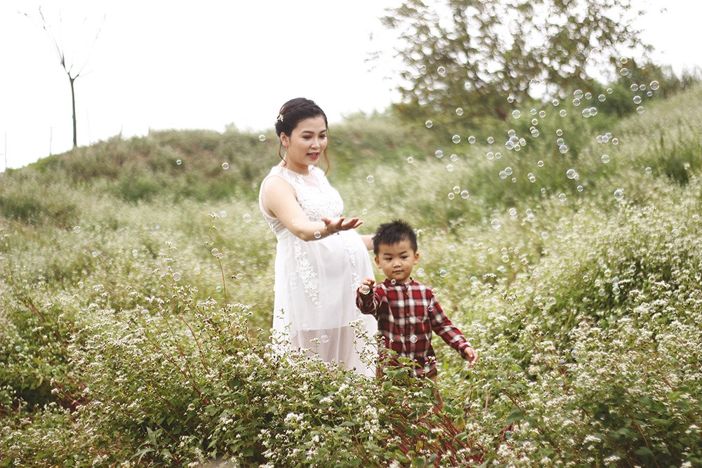 Mặc dù mang bầu được 8 tháng, nhưng chị Mai Trà Giang (30 tuổi, Long Biên) vẫn dành một buổi đến cánh đồng hoa tam giác mạch để chụp ảnh cùng người thân: “Mình muốn lưu giữ những khoảnh khắc đẹp trong giai đoạn này của thai kỳ cùng với gia đình của mình.”