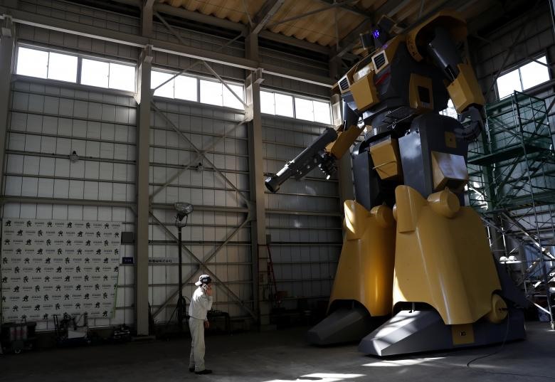 Kỹ sư Go Sakakibara sử dụng điện thoại để kết nối với một kỹ sư khác trong buồng lái của con robot. (Ảnh: REUTERS)